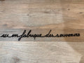 Phrase murale « Ici on fabrique des souvenirs » noire en plexiglas recyclé, sans clou ni trou – Atelier Suspendu