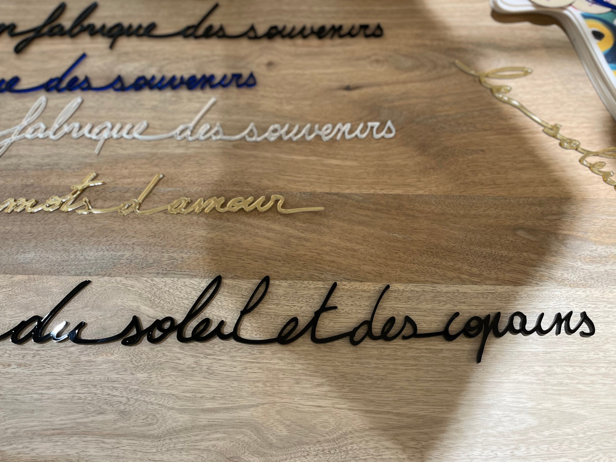 Phrase murale « Du soleil et des copains » noire en plexiglas recyclé – Atelier Suspendu